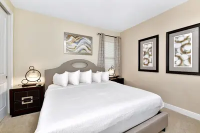 a bedroom with a large white bed with two night stands at Amazing Home With Theme Rooms, Game Rooms Near Disney With Waterpark & Resort Access At Encore Resort - 7647Wl in Kissimmee