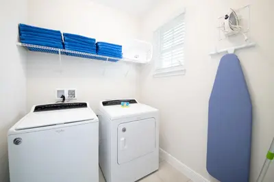 a laundry room with a washing machine and a blue tie at Vibrant Home With Private Pool, Pool Table Near Disney With Waterpark & Resort Access At Encore Resort - 7707Gr in Kissimmee