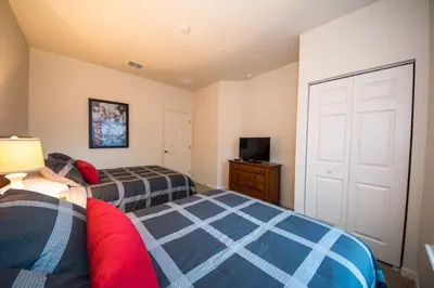 a bedroom with two beds and a television in it at HAPPY PORT, your home very close to entertainment in Kissimmee