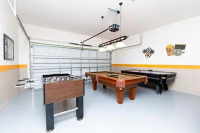 two ping pong tables in a room with two billards at Newly Remodeled 1 story - 5 Bed 5 Bath with Pvt Pool Spa And Game Room in Kissimmee