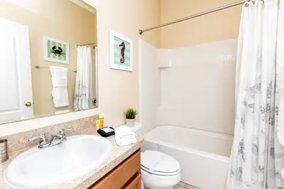 a bathroom with a sink and a tub and a toilet at Newly Remodeled 1 story - 5 Bed 5 Bath with Pvt Pool Spa And Game Room in Kissimmee