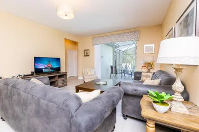 a living room with couches and a tv at Newly Remodeled 1 story - 5 Bed 5 Bath with Pvt Pool Spa And Game Room in Kissimmee