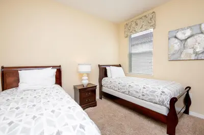 a bedroom with two beds and a window at Newly Remodeled 1 story - 5 Bed 5 Bath with Pvt Pool Spa And Game Room in Kissimmee