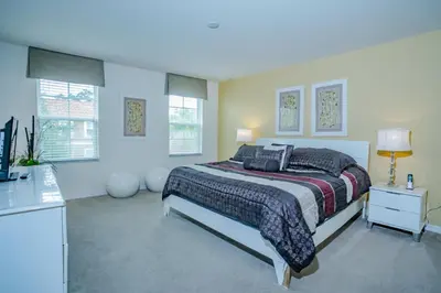 a bedroom with a bed and two windows at Fantastic 4br 3ba with Pvt Pool near to Disney in Kissimmee