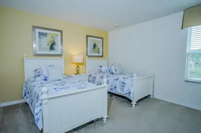 a bedroom with two beds and a lamp and a window at Fantastic 4br 3ba with Pvt Pool near to Disney in Kissimmee