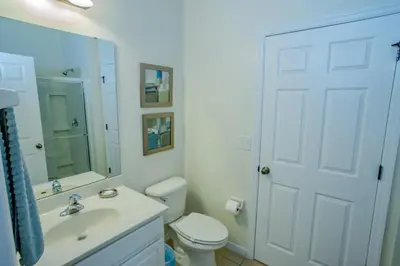 a bathroom with a toilet and a sink and a mirror at Fantastic 4br 3ba with Pvt Pool near to Disney in Kissimmee