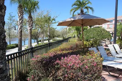 a patio with chairs and an umbrella and flowers at 205 - Disney, Universal, Convention Center in Orlando