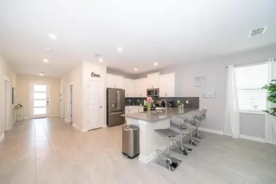 a large kitchen with a counter and chairs in it at 2705JT LUXURY 7 BED/5 BA (SANITIZED) in Kissimmee