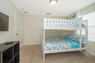 a white bunk bed in a room with a desk at 3087LL Townhouse 5 Bedrooms & 4 Bathrooms Pool in Kissimmee