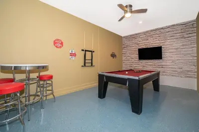 a room with a ping pong table and a bar at 2776LO VILLA 5 BED/5 BA (SANITIZED) in Kissimmee
