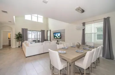 a dining room and living room with a table and chairs at 2776LO VILLA 5 BED/5 BA (SANITIZED) in Kissimmee