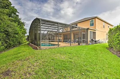 a glass house with a pool in a yard at 14 Mi to Disney Parks Spacious Kissimmee Home in Kissimmee