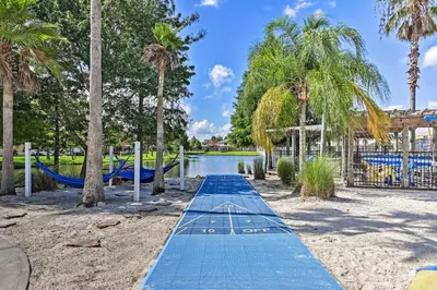 a blue slide in a park with palm trees at 14 Mi to Disney Parks Spacious Kissimmee Home in Kissimmee