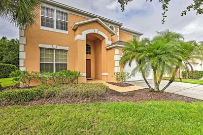 a house with a palm tree in front of it at 14 Mi to Disney Parks Spacious Kissimmee Home in Kissimmee