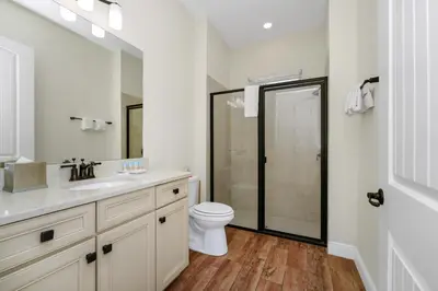 a white bathroom with a toilet and a sink at Sunny Cottage Near Disney With Margaritaville Resort & Island H2O Access - 8032Ls in Orlando