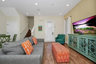 a living room with a couch and a flat screen tv at Sunny Cottage Near Disney With Margaritaville Resort & Island H2O Access - 8032Ls in Orlando