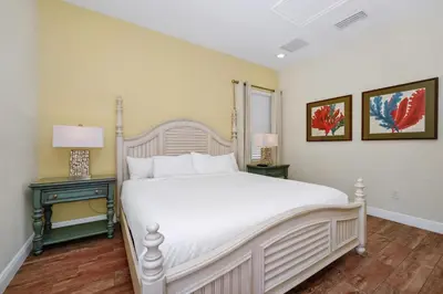 a bedroom with a large white bed and two tables at Sunny Cottage Near Disney With Margaritaville Resort & Island H2O Access - 8032Ls in Orlando