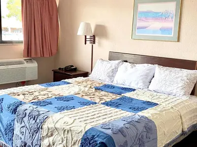 a bedroom with a bed with a blue and white quilt at REGENCY INN in Orlando