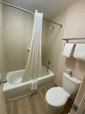 a bathroom with a toilet and a tub and a shower at REGENCY INN in Orlando