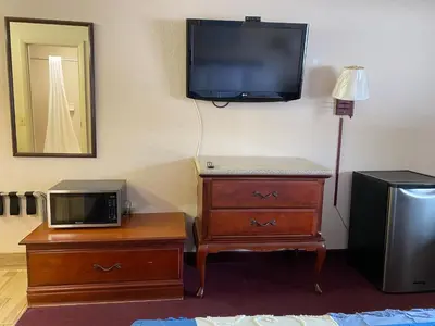 a room with a television and a dresser with a microwave at REGENCY INN in Orlando