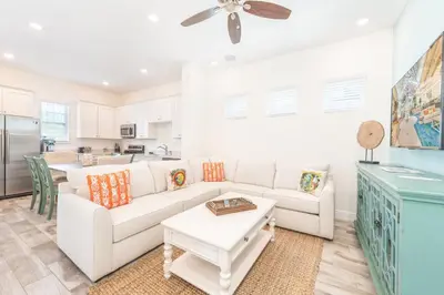 a living room with a white couch and a table at Blue Shores Cottage Near Disney With Margaritaville Resort & Island H2O Access - 8079Kd in Orlando