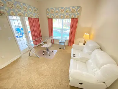 a living room with a white couch and a table at Mickeys Corner - Fantastic 5BR with Large Private Garden Pool Hot Tub Game Room Gas BBQ 2 Miles to Disney in Orlando