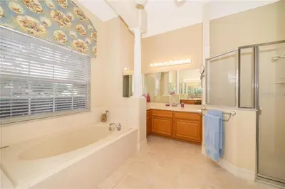 a bathroom with a tub and a shower and a sink at Mickeys Corner - Fantastic 5BR with Large Private Garden Pool Hot Tub Game Room Gas BBQ 2 Miles to Disney in Orlando