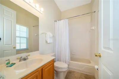 a bathroom with a sink and a toilet and a shower at Mickeys Corner - Fantastic 5BR with Large Private Garden Pool Hot Tub Game Room Gas BBQ 2 Miles to Disney in Orlando