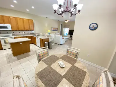 a kitchen and dining room with a table and chairs at Mickeys Corner - Fantastic 5BR with Large Private Garden Pool Hot Tub Game Room Gas BBQ 2 Miles to Disney in Orlando
