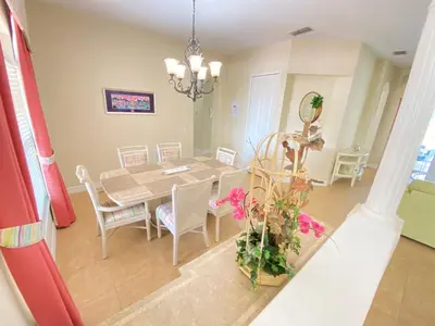 a dining room and kitchen with a table and chairs at Mickeys Corner - Fantastic 5BR with Large Private Garden Pool Hot Tub Game Room Gas BBQ 2 Miles to Disney in Orlando