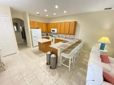 a kitchen with a couch and a table in a room at Mickeys Corner - Fantastic 5BR with Large Private Garden Pool Hot Tub Game Room Gas BBQ 2 Miles to Disney in Orlando