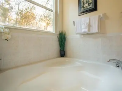 a white bath tub in a bathroom with a window at Luxurious With Privacy In 5 Bedroom With Private Pool By Florida Dream Homes in Kissimmee