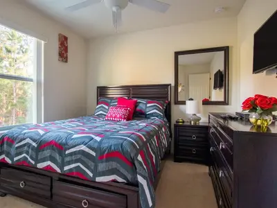 a bedroom with a bed with a dresser and a mirror at Luxurious With Privacy In 5 Bedroom With Private Pool By Florida Dream Homes in Kissimmee