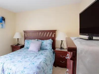 a bedroom with a bed and a flat screen tv at 4 Bed And 3 Bath In Perfect Location With Pool By Florida Dream Home in Kissimmee
