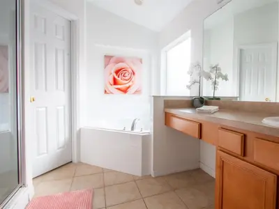 a bathroom with a sink and a pink rose on the wall at 4 Bed And 3 Bath In Perfect Location With Pool By Florida Dream Home in Kissimmee