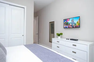 a white bedroom with a bed and a dresser at Gorgeous 4 Bedroom Family Friendly Close to Disney 7573 in Orlando
