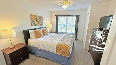 a bedroom with a bed and a flat screen tv at Villas at Seven Dwarfs - Close to Disney in Kissimmee