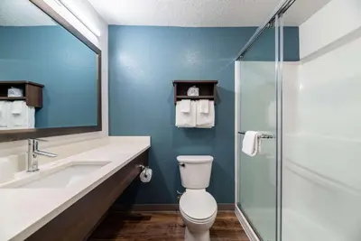 a bathroom with a toilet and a sink and a shower at WoodSpring Suites Sanford North I-4 Orlando Area in Sanford