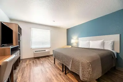 a bedroom with a bed and a blue wall at WoodSpring Suites Sanford North I-4 Orlando Area in Sanford