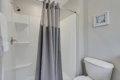 a bathroom with a shower curtain and a toilet at 8 Mi to Disney Villa with Screened Pool and Lanai in Kissimmee