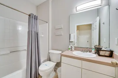 a bathroom with a sink and a toilet and a mirror at 8 Mi to Disney Villa with Screened Pool and Lanai in Kissimmee