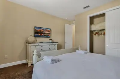 a bedroom with a white bed and a dresser at 491 Lasso dr in Orlando