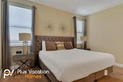 a bedroom with a large bed and two windows at 7617 Brookhurst lane in Orlando