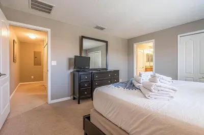 a bedroom with a bed and a tv and a mirror at Resort Retreat in Kissimmee