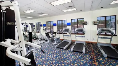 a gym with rows of treadmills and machines at Resort Retreat in Kissimmee