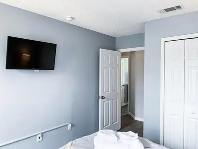 a bedroom with a blue wall with a tv on the wall at Crystal Villa in Kissimmee