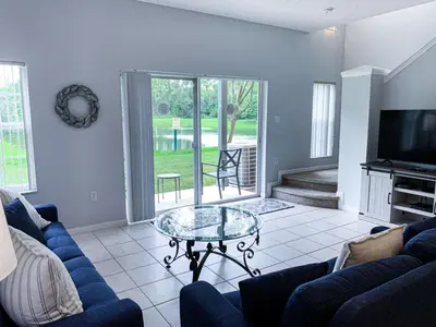 a living room with a blue couch and a glass table at Crystal Villa in Kissimmee