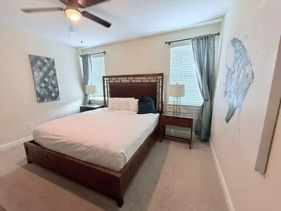 a bedroom with a bed and a ceiling fan at 520-IBRAHIM · 520 - 8BD Home PoolSpa - MovieGame room in Orlando