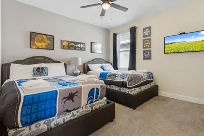 a bedroom with two beds and a flat screen tv at 551 Villa 8BD PoolSpa - Game room Movie room in Orlando