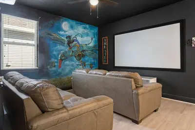 a living room with two couches and a white screen at 551 Villa 8BD PoolSpa - Game room Movie room in Orlando